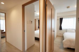 a room with a door leading to a bedroom at New Normal Hotel in NAGO ニューノーマルホテルイン名護 in Nago