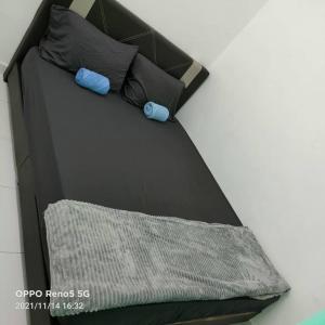 a black bed with two pillows and a blanket at NVACASTAY in Marang