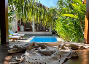 a swimming pool with a blanket next to a house at Villa Majegau 2 by Deasha in Seminyak