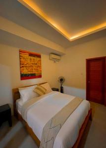 a bedroom with a large white bed in a room at Villa Majegau 2 by Deasha in Seminyak