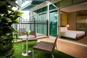 a balcony with a bed and a table and chairs at Dorsett Putrajaya in Putrajaya