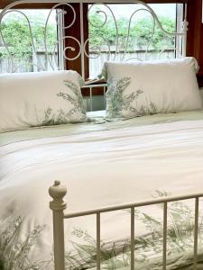 a bed with white sheets and pillows on it at Private Bath Ensuite Room Eastwood/MQ Uni park in Sydney