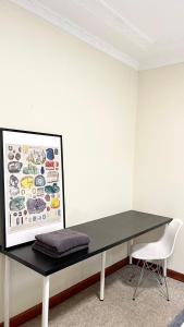 a black desk with a picture on a wall at Private Bath Ensuite Room Eastwood/MQ Uni park in Sydney
