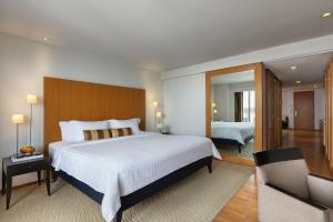 a hotel room with a large bed and a living room at Tower Club at lebua in Bangkok