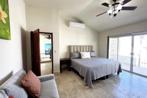 1 dormitorio con cama, sofá y ventilador de techo en Villa Cola de Ballena, Pedregal @ Cabo's Downtown en Cabo San Lucas