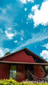 a red building with a sky in the background at Pousada Barriga da Lua in Serra do Cipo