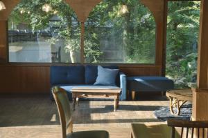 a living room with a blue couch and a table at 野窓 Nomadノマド Tsuwano GuestHouse & Cafe Lounge in Tsuwano