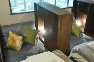 una camera con divano e sedia con cuscini di 野窓 Nomadノマド Tsuwano GuestHouse & Cafe Lounge a Tsuwano