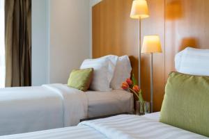 a hotel room with two beds and a chair at Tower Club at lebua in Bangkok