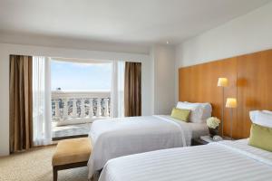 a hotel room with two beds and a window at Tower Club at lebua in Bangkok