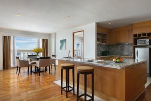 a kitchen with a counter and a dining room at Tower Club at lebua in Bangkok