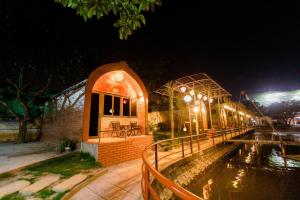 a building with a pool of water at night at Hoa Lu Garden in Ninh Binh