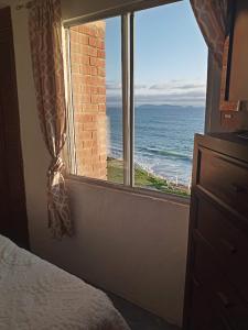 a bedroom with a window with a view of the ocean at Recámara frente al mar, cama King, tv, wifi in Tijuana