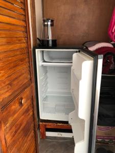 an empty refrigerator with its door open in a room at Recámara frente al mar, cama King, tv, wifi in Tijuana