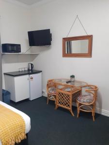 a room with a bed and a table and chairs at Hope Street Apartments in Dunedin