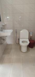 ein Bad mit einem WC und einem Waschbecken in der Unterkunft Hilltop Lodge in Guwahati