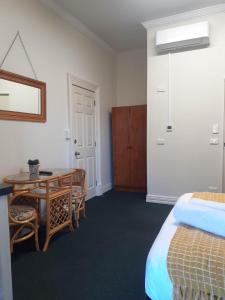 a bedroom with a desk and a bed and a table at Hope Street Apartments in Dunedin