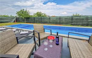 een patio met een tafel met wijnglazen en een zwembad bij Amazing Home In Marcana With Wifi in Marčana