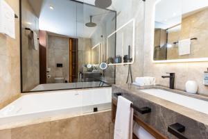 y baño con bañera, lavabo y espejo. en Grand Palladium Kantenah Resort & Spa - All Inclusive, en Akumal