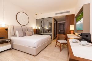 1 dormitorio con 1 cama blanca y sala de estar en Grand Palladium Kantenah Resort & Spa - All Inclusive, en Akumal