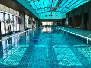 an indoor swimming pool with a blue ceiling at Grand K Hotel Suites Hanoi in Hanoi