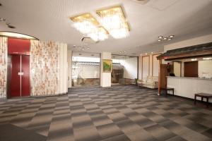 a lobby with a large room with a checkerboard floor at Hotel Shin Makomo in Itako