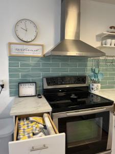 a kitchen with a stove and a clock on the wall at Casa Di Nonna in Wasaga Beach