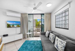 a living room with a gray couch and a blue rug at Mooloolaba Beach Club Paradise 2 Bedroom Apartment in Mooloolaba