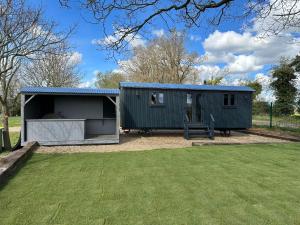 a green shed with a bench in a yard at Whitwell and Reepham Station - Meadow View in Norwich