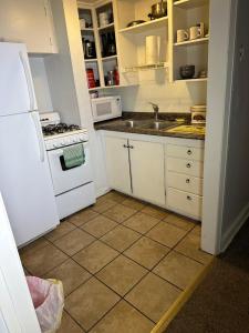 uma cozinha com um frigorífico branco e um lavatório em Beautiful SLC apartment in the avenues em Salt Lake City