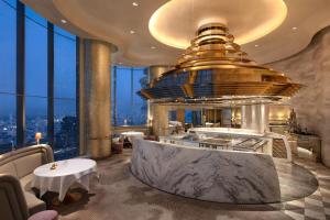a restaurant with a large tub in a room with windows at Tower Club at lebua in Bangkok