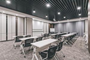 a classroom with tables and chairs and a whiteboard at Atour Hotel (Wuxi Berkesy) in Wuxi