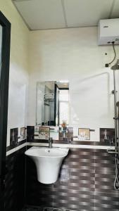 W łazience znajduje się biała umywalka i lustro. w obiekcie Jade Hotel w mieście Phong Nha