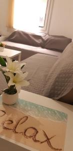 a sign on a table with a flower and a bed at Luxury apartment near metro by hospitality gr in Athens