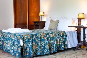 a bedroom with a bed with a blue and white blanket at The Big House-grand comfort at Serra da Estrella in Gouveia