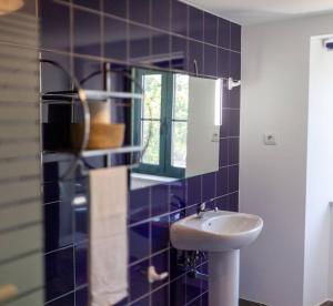 a blue tiled bathroom with a sink and a mirror at The Big House-grand comfort at Serra da Estrella in Gouveia +31 photos