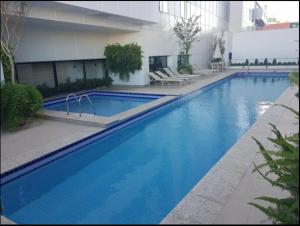 uma grande piscina azul em frente a um edifício em Conjunto Estudio e Duplex Selenita em Barueri