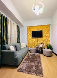 sala de estar con sofá y TV en la pared en Cerevic, en Cainta