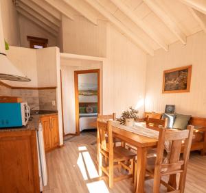 a kitchen and dining room with a table and chairs at Pitihué Aparts in El Chalten