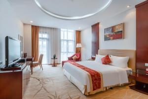 済南市にあるGrand Metropark Hotel Shandongのベッド1台、薄型テレビが備わるホテルルームです。