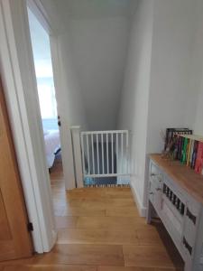 a hallway with a crib in a room with a stairway at Top of the House in Bognor Regis