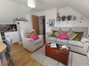 a living room with two couches and a table at Top of the House in Bognor Regis