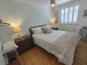 a bedroom with a bed and a chair and a window at Top of the House in Bognor Regis