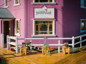 a pink building with a bench in front of it at Pitihué Aparts in El Chalten