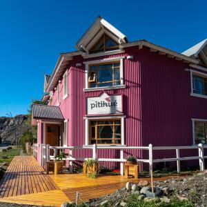 um edifício cor-de-rosa com um deque de madeira à sua frente em Pitihué Aparts em El Chaltén