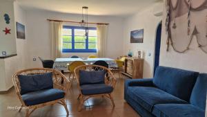 uma sala de estar com um sofá, cadeiras e uma mesa em Acacies 25 em Torroella de Montgrí