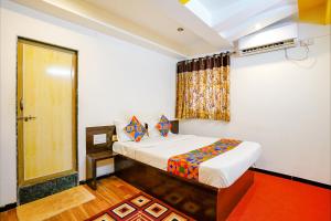 a bedroom with a bed and a window and a door at FabExpress Sai Chatra in Nashik