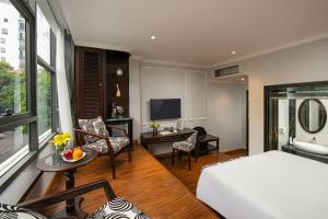 a bedroom with a bed and a living room at Salute Premium Hotel & Spa in Hanoi