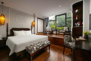 a bedroom with a bed and a desk and a chair at Salute Premium Hotel & Spa in Hanoi