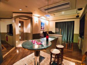 una sala de estar con una mesa con flores. en K2 SKY Resort Itoshima Love Hotel, en Itoshima